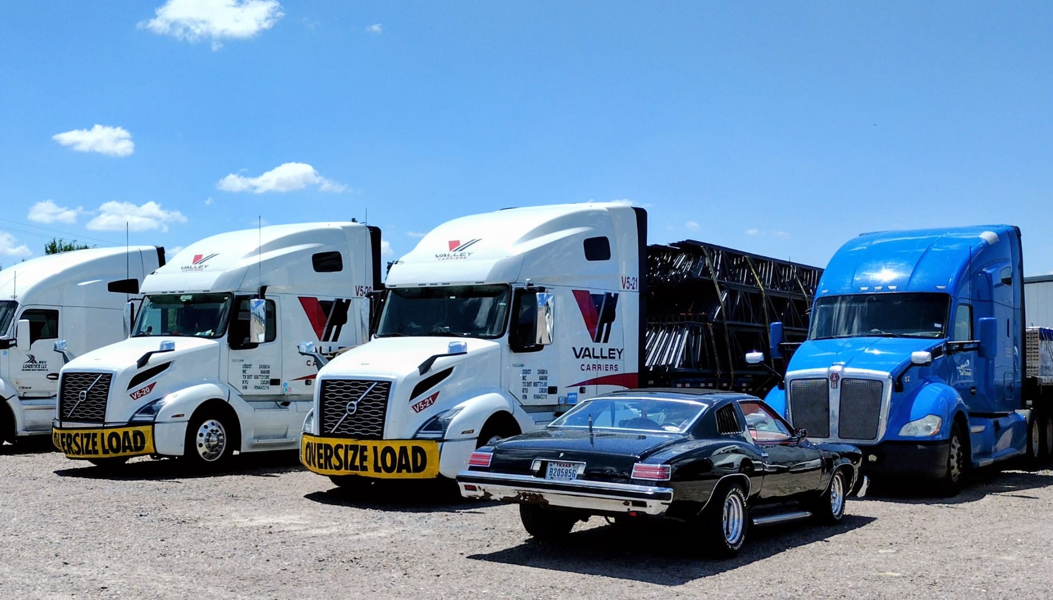 Valley Carriers tractors with oversize load banners at the yard